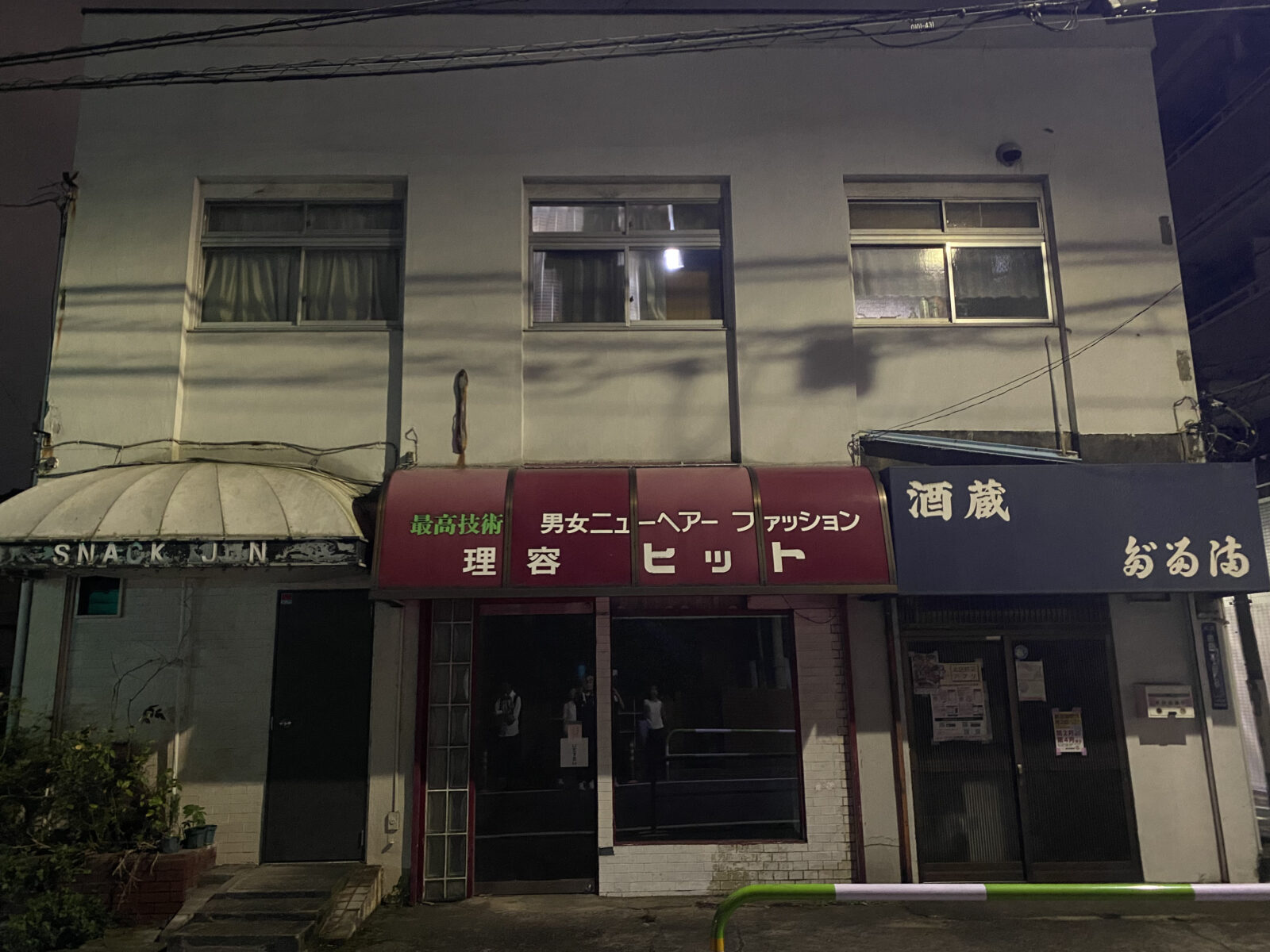 理容店や飲食店の看板が残る街並み
