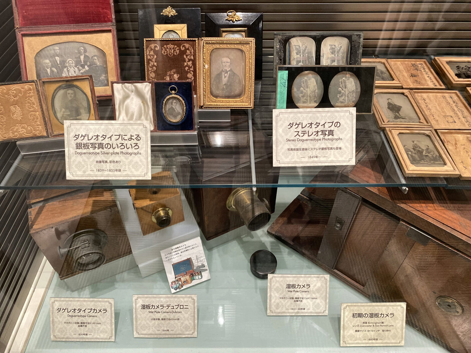 ダゲレオタイプの肖像写真と初期のカメラを並べた展示