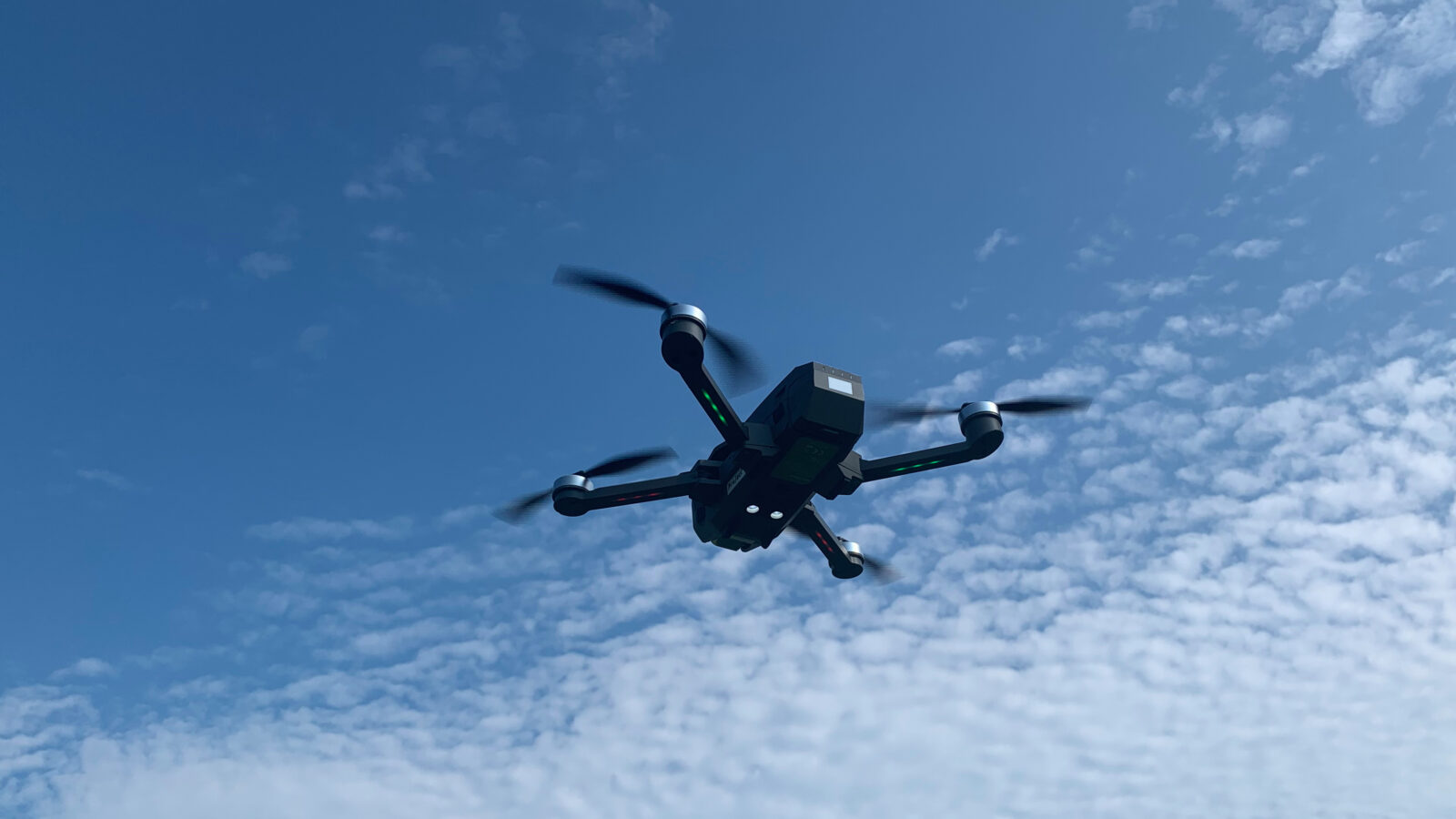 空を飛ぶクワッドローター型ドローン