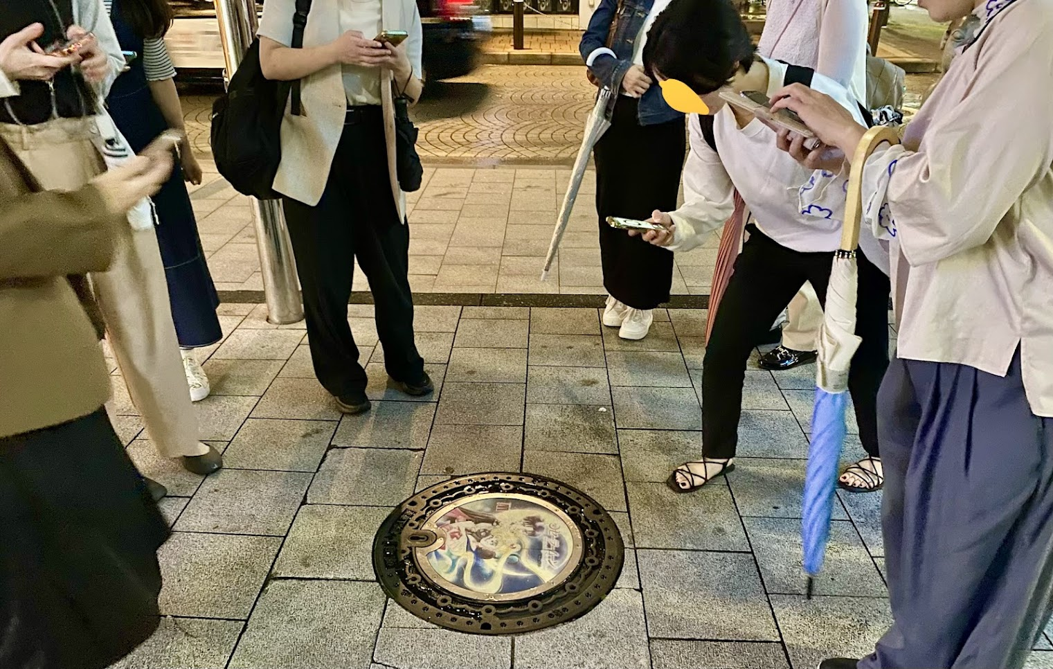 麻布十番駅付近のセーラームーンデザインマンホールを見る参加者