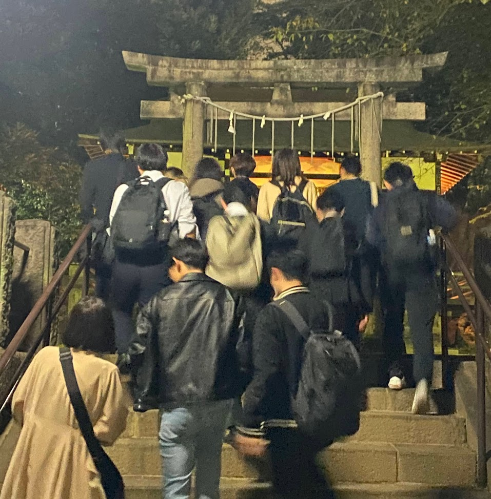 夜の上田端八幡神社の鳥居と参道の階段を歩く参加者