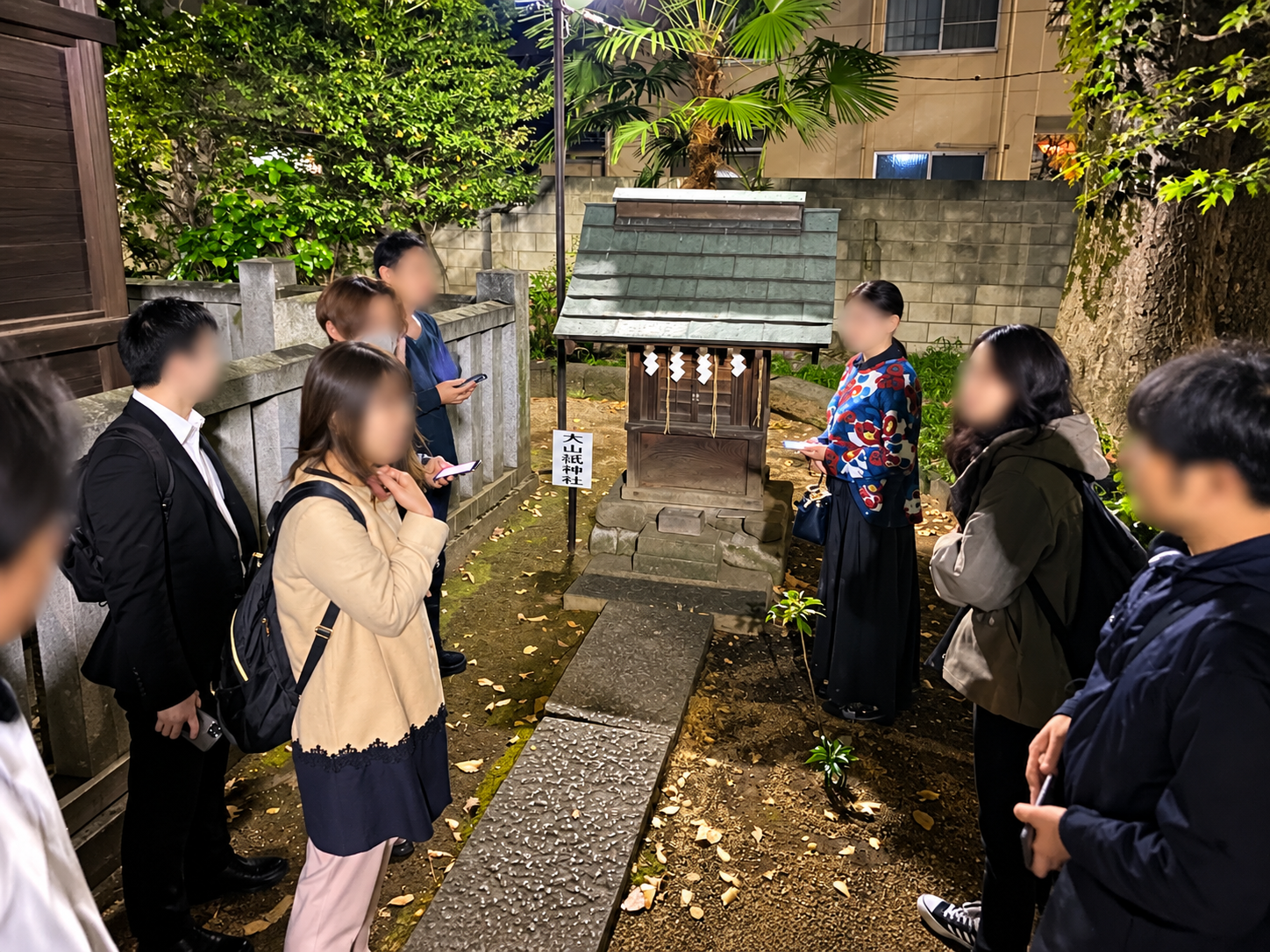 田端八幡神社境内の大山祇神社の小祠と見学する参加者