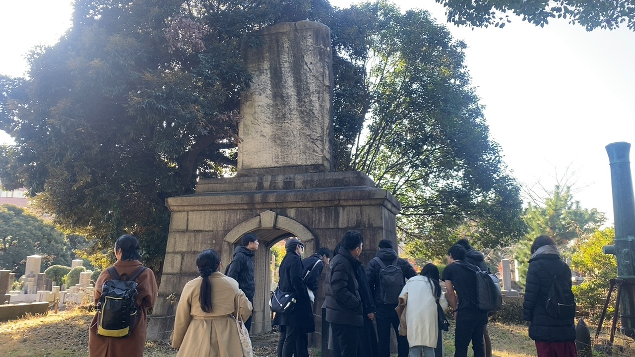 青山霊園の石造慰霊碑を見学する参加者