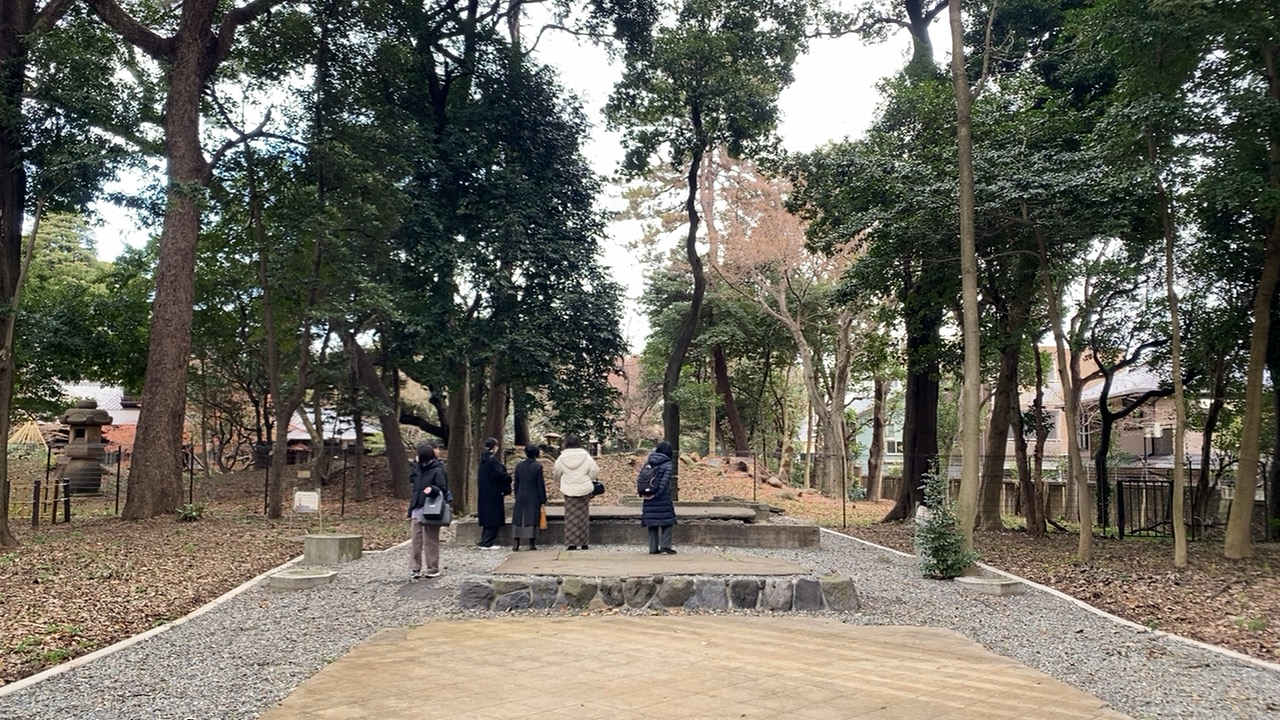 旧前田家本邸祖霊社跡地の石造基礎と石灯籠が残る林間の風景