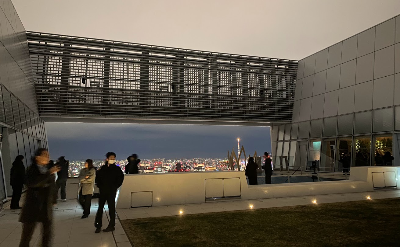 地上約250mのTOKYO NODE49階屋上庭園と夜景を眺める人々