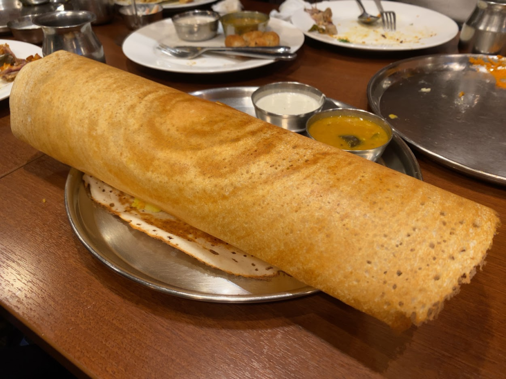 大きく筒形に巻かれた南インド料理ドーサ サンバルとチャツネ添え