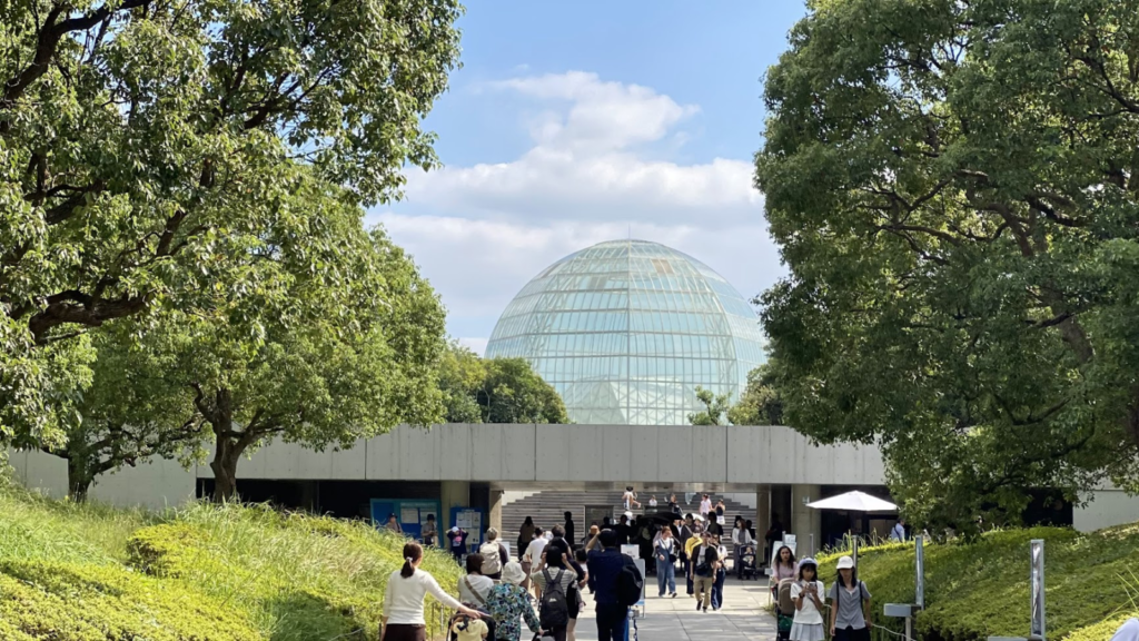 葛西臨海水族園の入口から見えるガラスドームと緑の園路、2026年10月10日