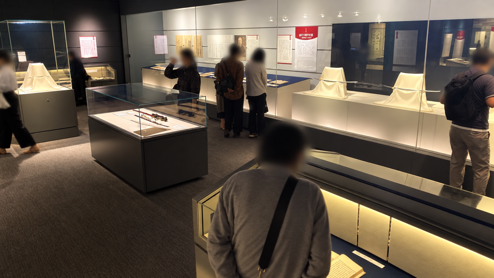 國學院大學博物館の刀剣学総論展で史料や刀剣を鑑賞する来館者と展示ケース