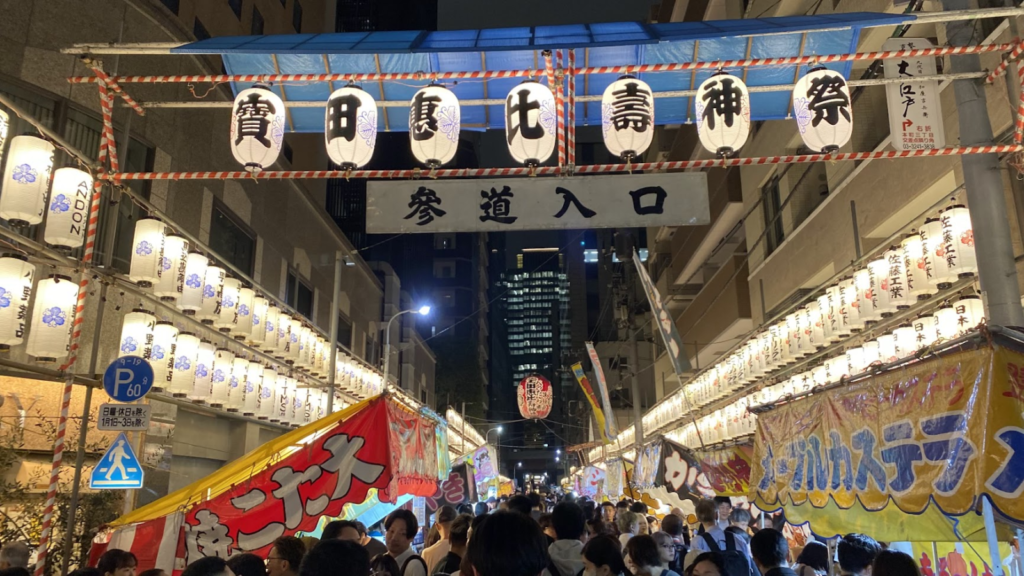 寶田恵比寿神社の参道に並ぶ奉納提灯と混雑した夜の露店