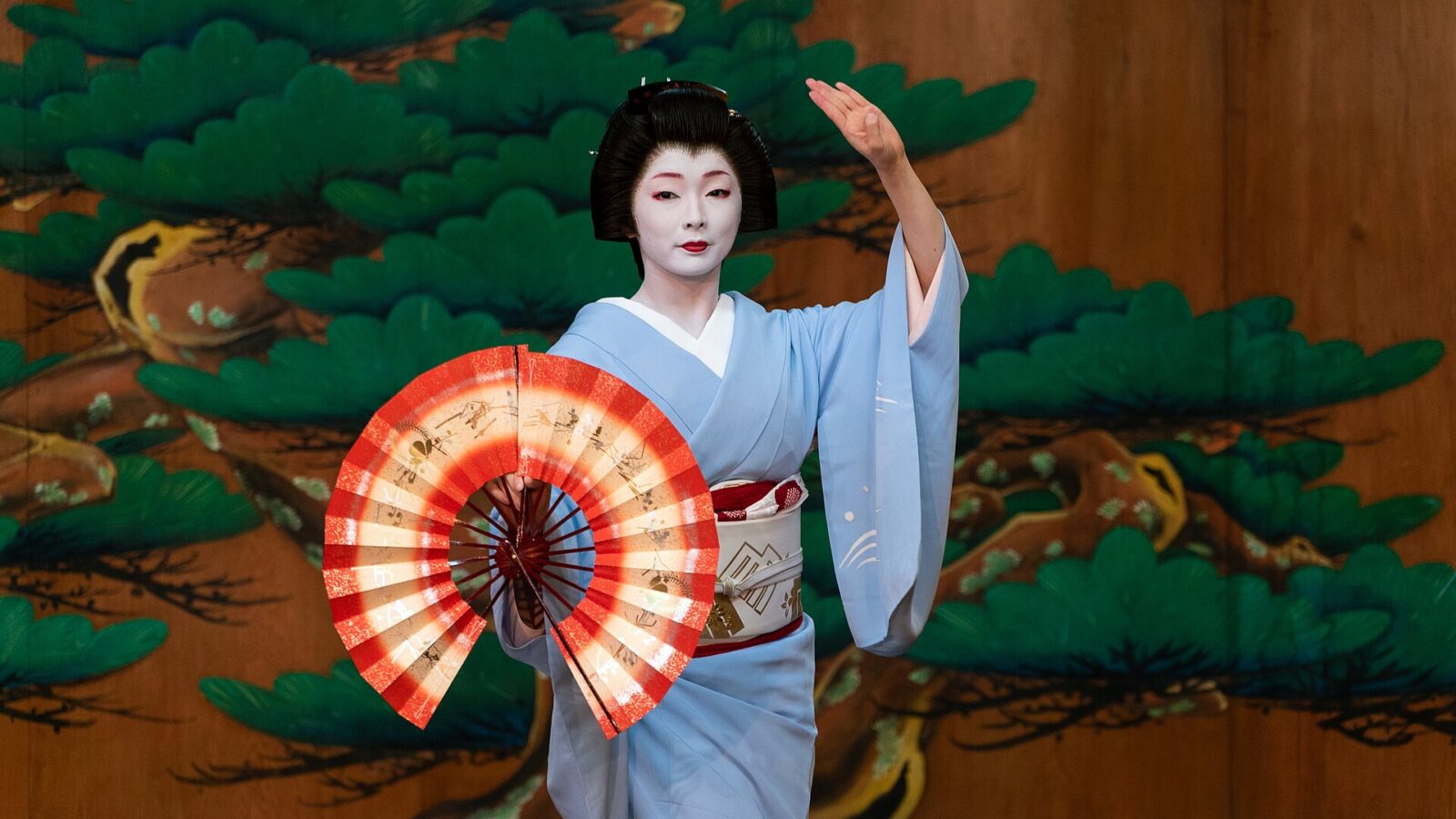 京都の川村能舞台で二本の舞扇を手に日本舞踊を披露する芸妓