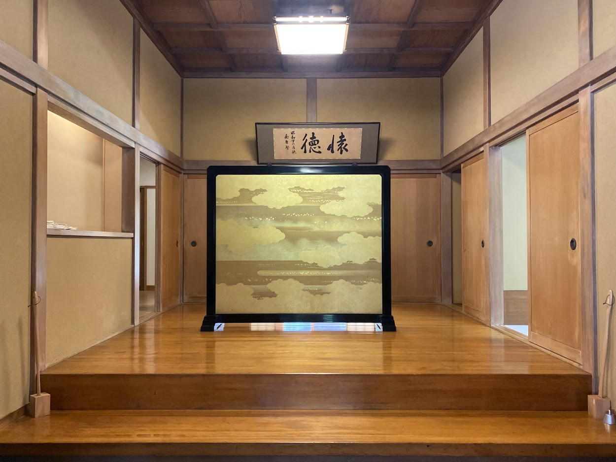 懐徳館の玄関内部に掲げられた「懐徳」の額と装飾された衝立