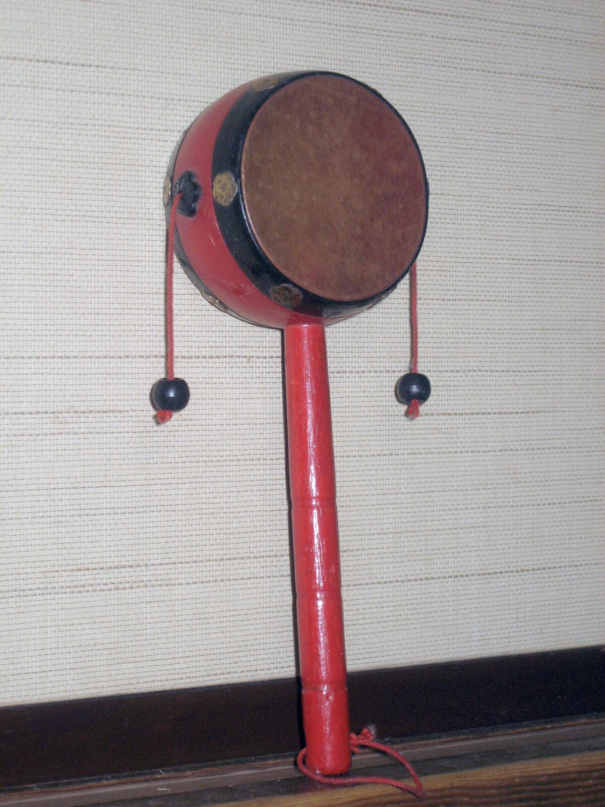 日本の伝統玩具でんでん太鼓。柄を回して左右の玉で太鼓を鳴らす