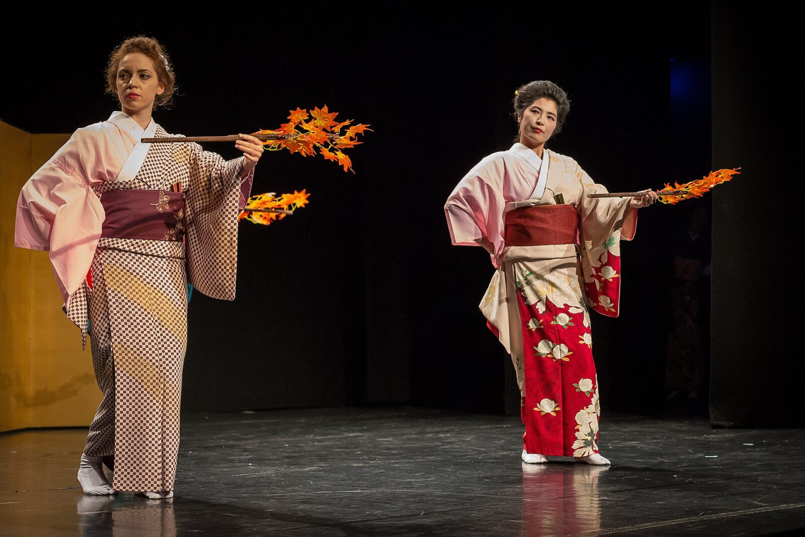 紅葉を飾った扇を持った二人が着物姿で日本舞踊「秋の色種」を踊る舞台
